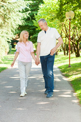 Obraz premium Active and happy mature couple walking in the park