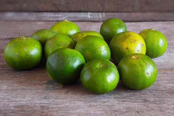 Fresh Green Lemons on Wooden for Background Uses.