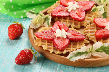 Strawberry dessert with cream on a wooden platter against