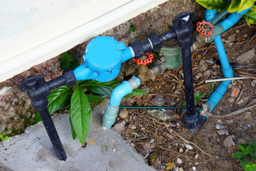 Old and dirty tab water pipe and meter with waterspout on ground