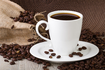 Naklejka premium Filiżanka kawy z nasionami kawy
