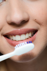 mouth close-up of a beautiful young woman brushing her teeth