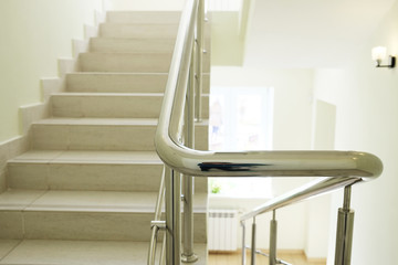 Staircase in modern building. Closeup stainless steel handrails.