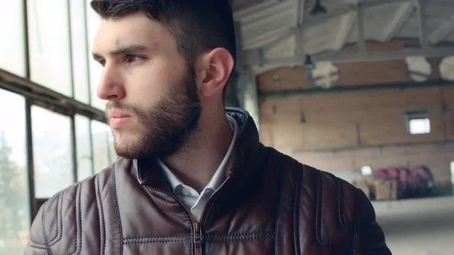 Cool seductive man in browm leather jacket