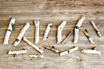 Birch tree trunks and branches on natural wood background