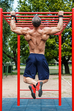 Man doing pull-ups on horizontal bar