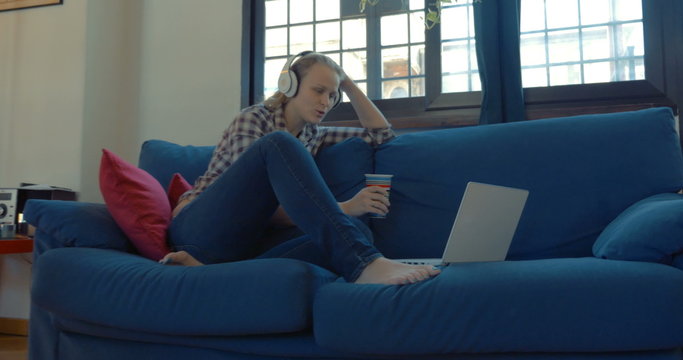 Woman on the sofa at home having video chat 