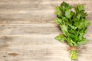 bunch of parsley tied with rope, on old wooden board
