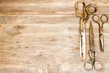 Old scissors on wooden background. Copy space to right.