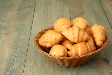 Croissants in a basket on wooden background