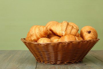 Croissants in a basket on wooden background