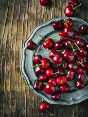 Sweet cherries on vintage plate. Top view