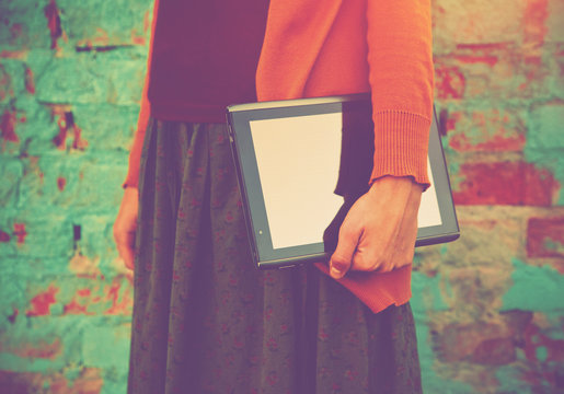 Hands Holding Digital Tablet Pc On Colorful Brick Wall Backgroun