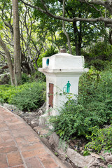 A litter bin in a park on the grass