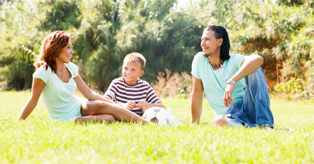 Fototapeta premium family of three resting at park