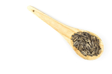 Sunflower seeds in wooden spoon isolated on white