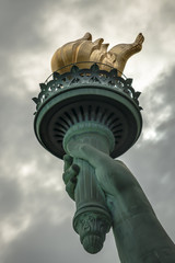 Closeup of the torch of Lady Liberty on a cloudy day © Victor Moussa