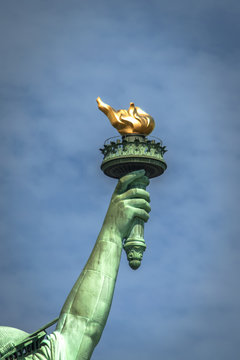 Closeup of the torch of Lady Liberty on a cloudy day
