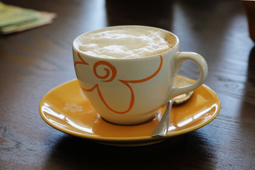 Hot cappuccino coffee on the wooden table