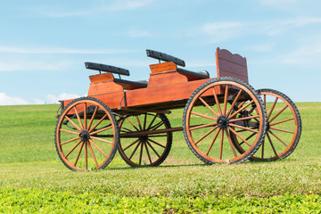 Fototapeta na wymiar historic carriage on beautiful field and Blue skies 