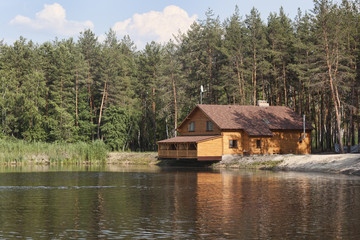 Fototapeta na wymiar House in the woods above the lake