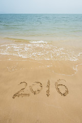 Year 2016 written in sand, on tropical beach