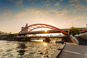 modern bridge over river at sunset