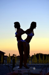 two girls backlit by the sea