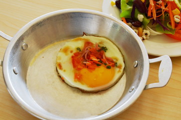 fried eggs topping slice ham on the pan