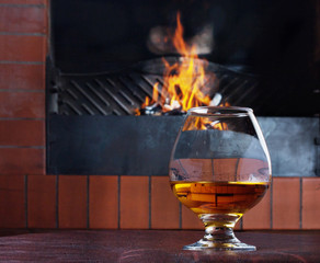 Two glasses of cognac on the old brick fireplace