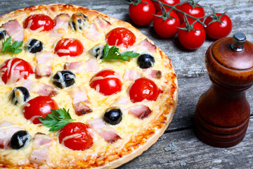 pizza with bacon, olives and tomato