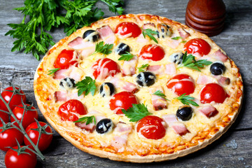 pizza with bacon, olives and tomato