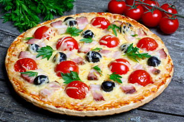 pizza with bacon, olives and tomato