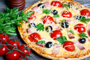 pizza with bacon, olives and tomato