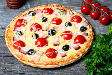 pizza with bacon, olives and tomato
