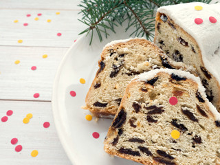 German Christmas cake on the white plate sprinkled with confetti