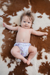 Cute baby with beautiful blue eyes smiling lying in bed