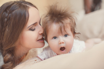 Portrait of happy mother with baby,posing lying on the bed