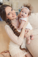 Portrait of happy mother with baby,posing lying on the bed