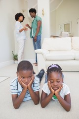 Happy siblings sitting on the floor using laptop