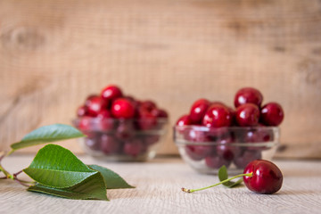 two glass plates with cherries on the table
