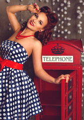 Red hair pin-up woman portrait near telephone booth