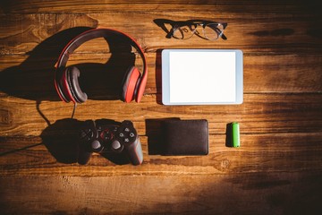 Tablet and USB key next to glasses wallet and joystick 