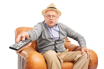 Angry senior pressing buttons on a remote control