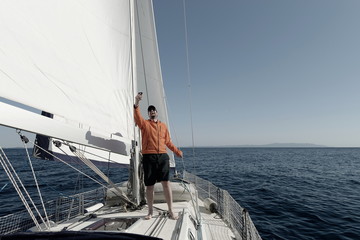 Man sailing with sails out on a sunny day and making selfie