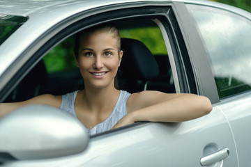 Fototapeta na wymiar Smiling attractive woman driving a car