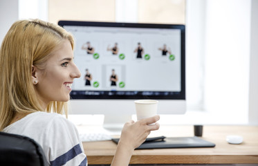 Happy woman holding cup with coffee in office