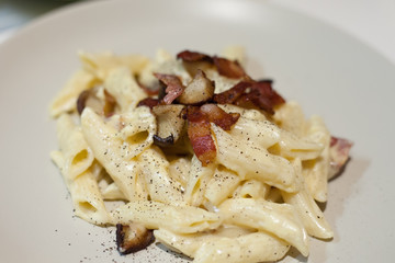Spaghetti carbonara with bacon on a plate.