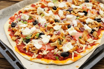 Raw al funghi pizza with chanterelle mushrooms and olives on bak