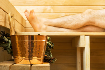 Spa accessories in sauna. Man on background.